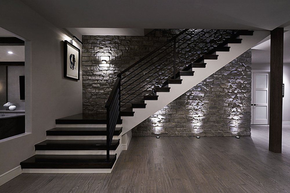 A black and white staircase with a brick wall behind it