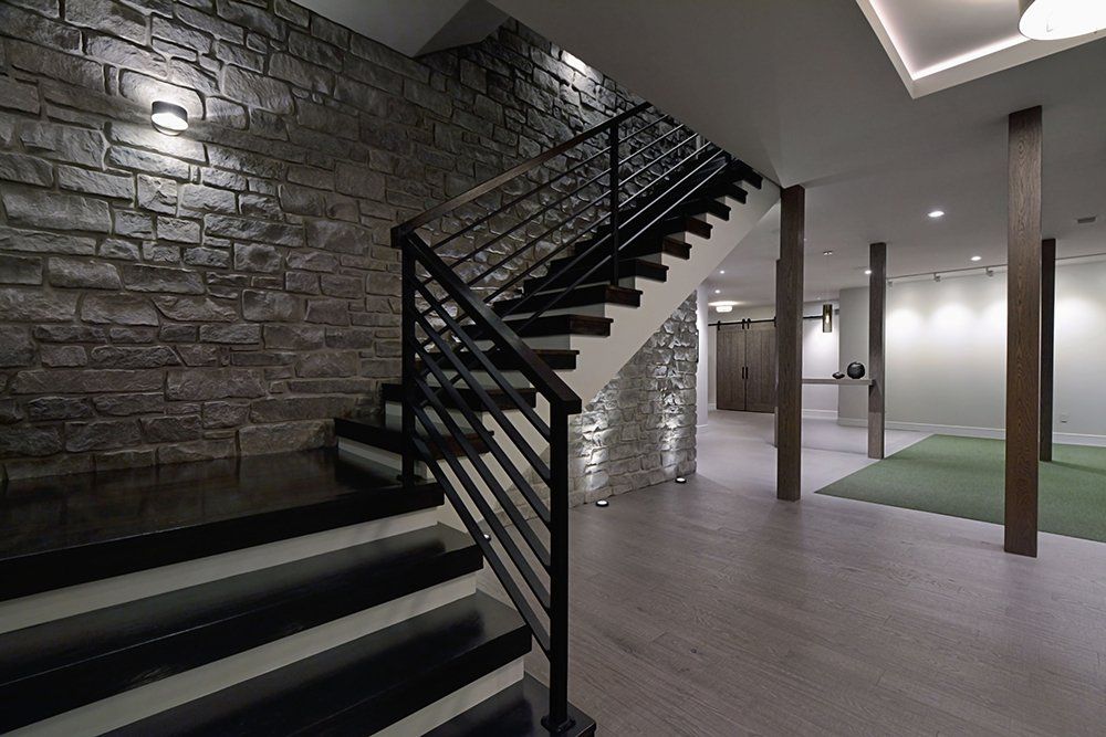 A staircase in a basement with a brick wall