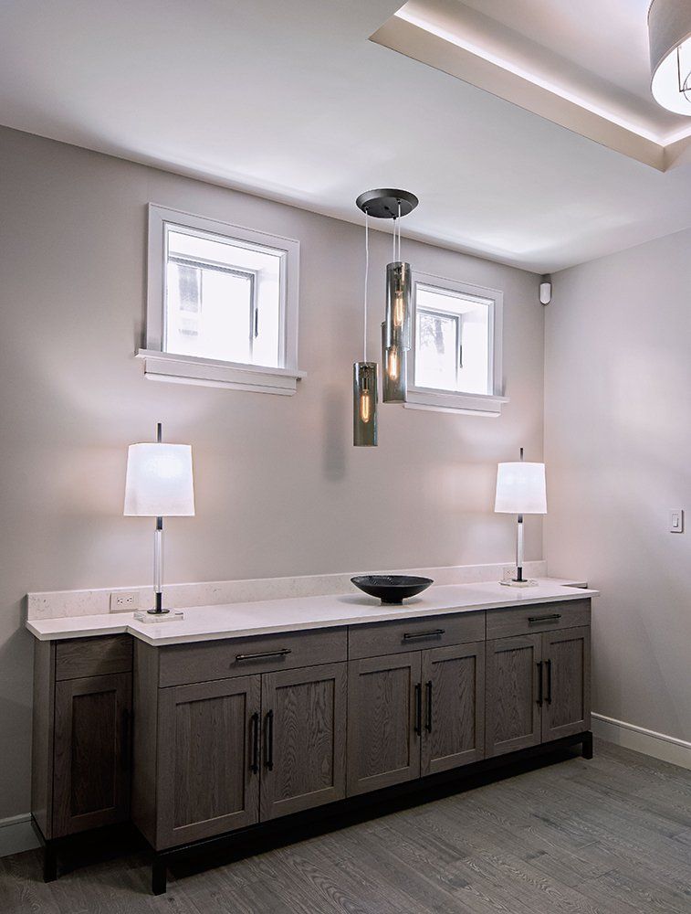 A room with cabinets and lamps and a bowl on the counter