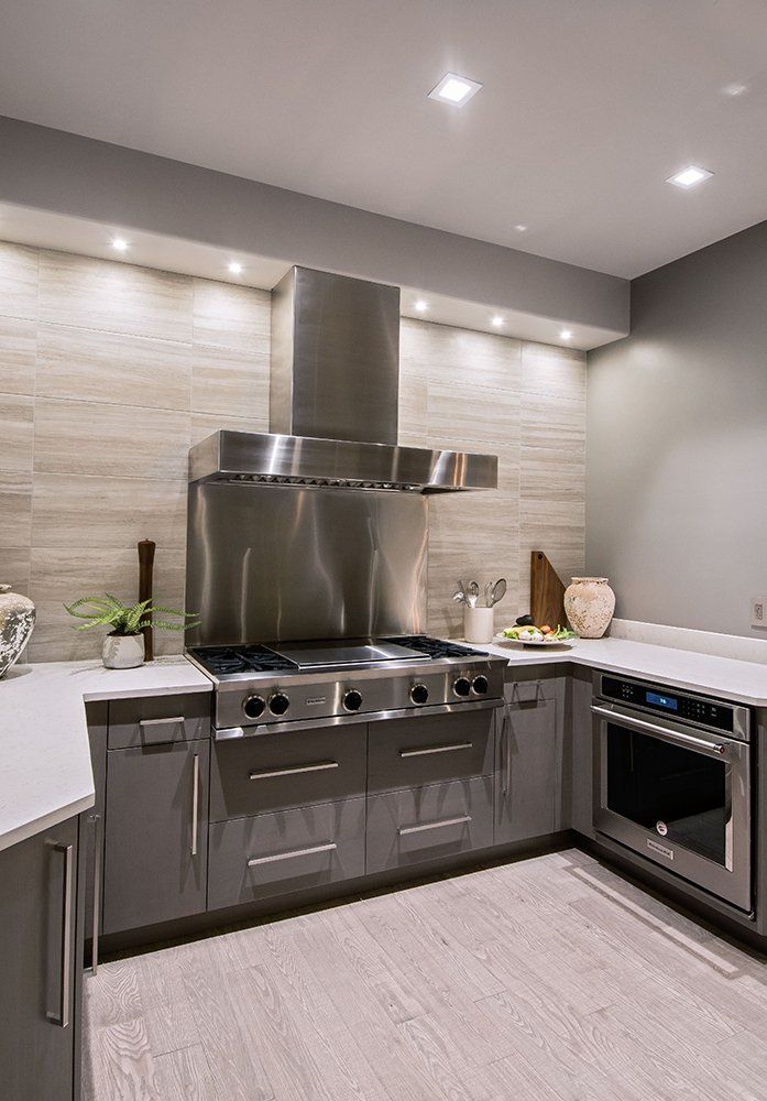 A kitchen with stainless steel appliances and a stove top oven