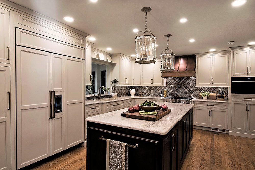 A kitchen with white cabinets and a large island