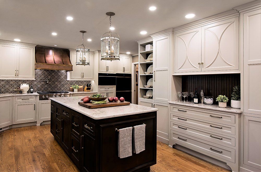 A kitchen with a large island and white cabinets