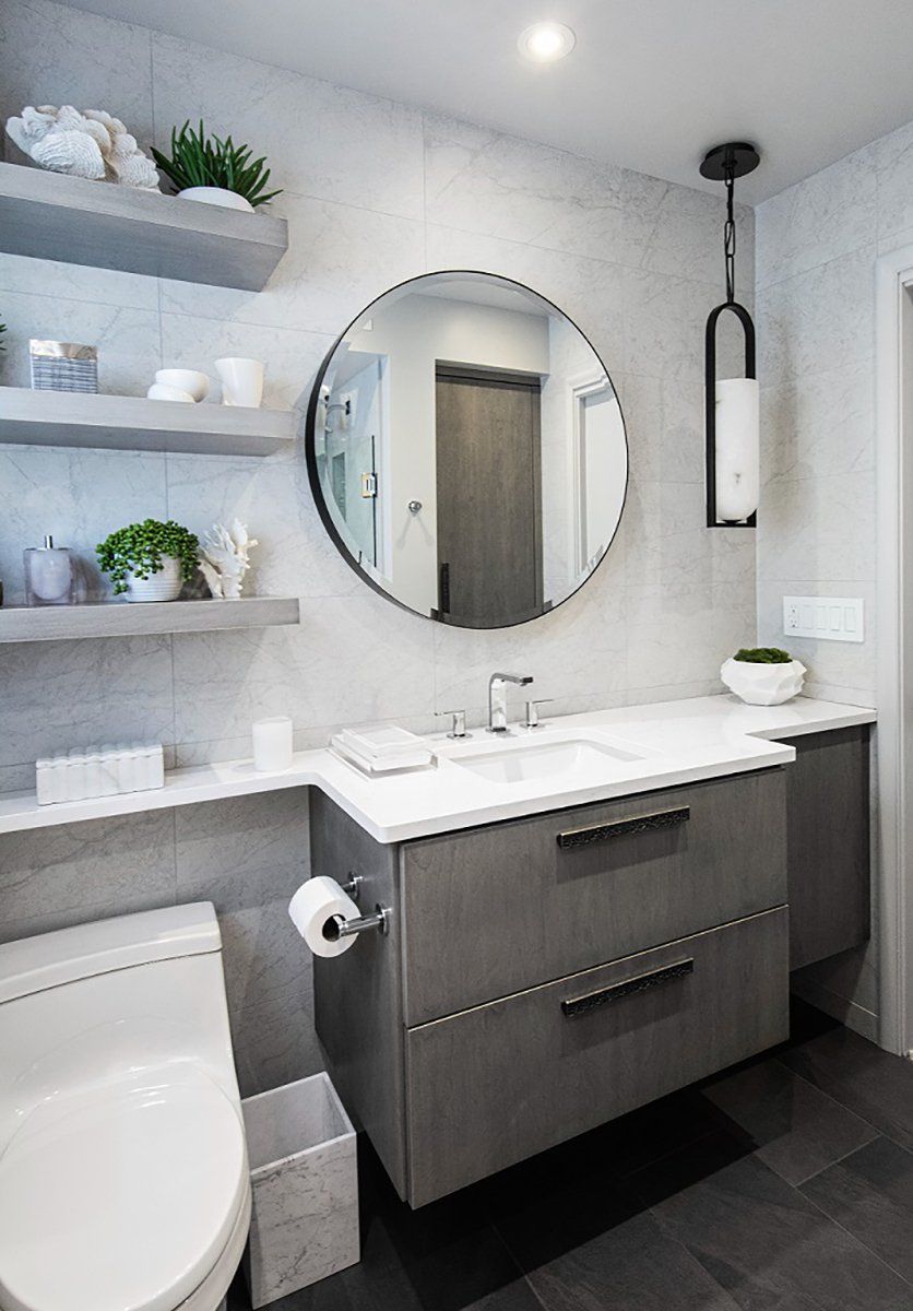 A bathroom with a toilet , sink , mirror and shelves