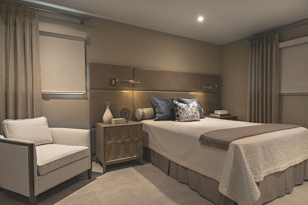 A bedroom with a large bed and a chair