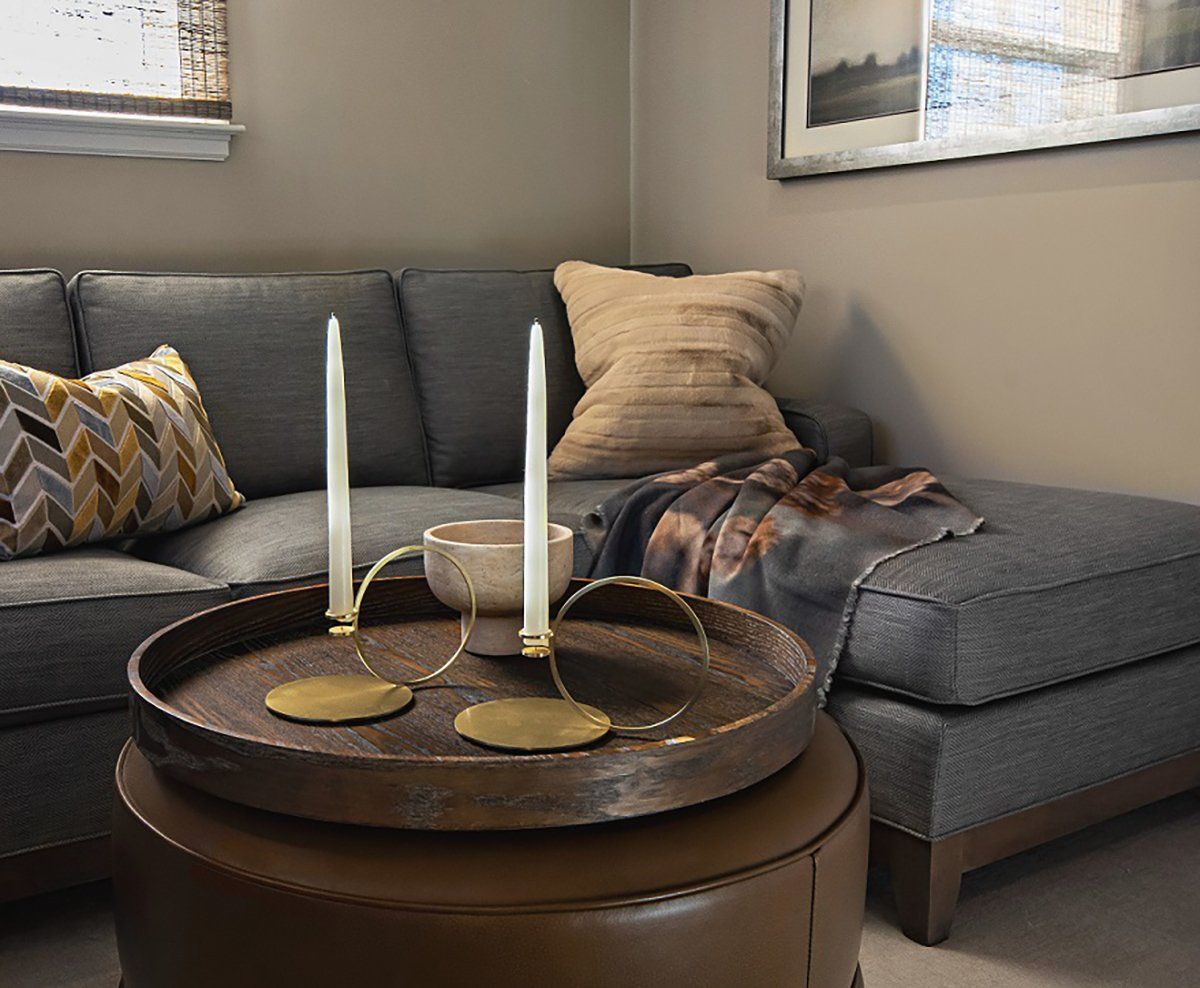 A living room with a couch and a tray with candles on it