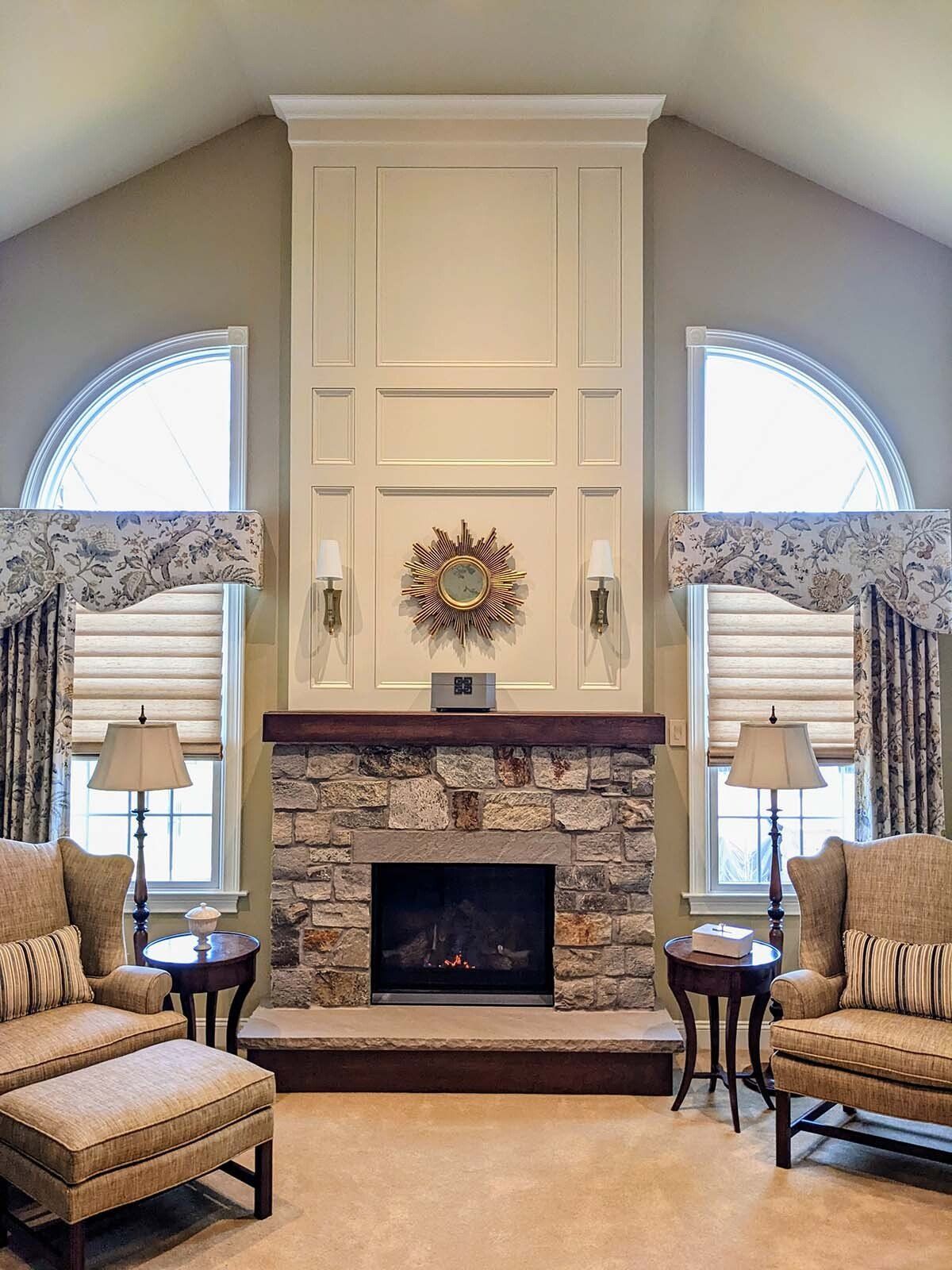 A living room with a large stone fireplace