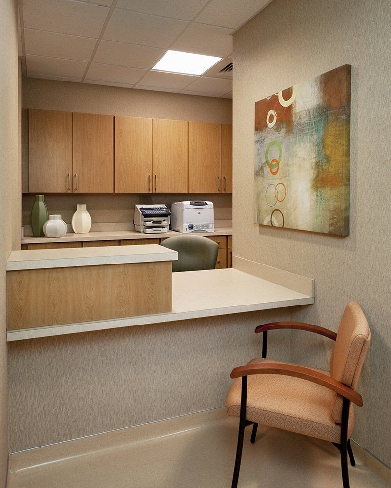 A room with a chair and a printer on the wall