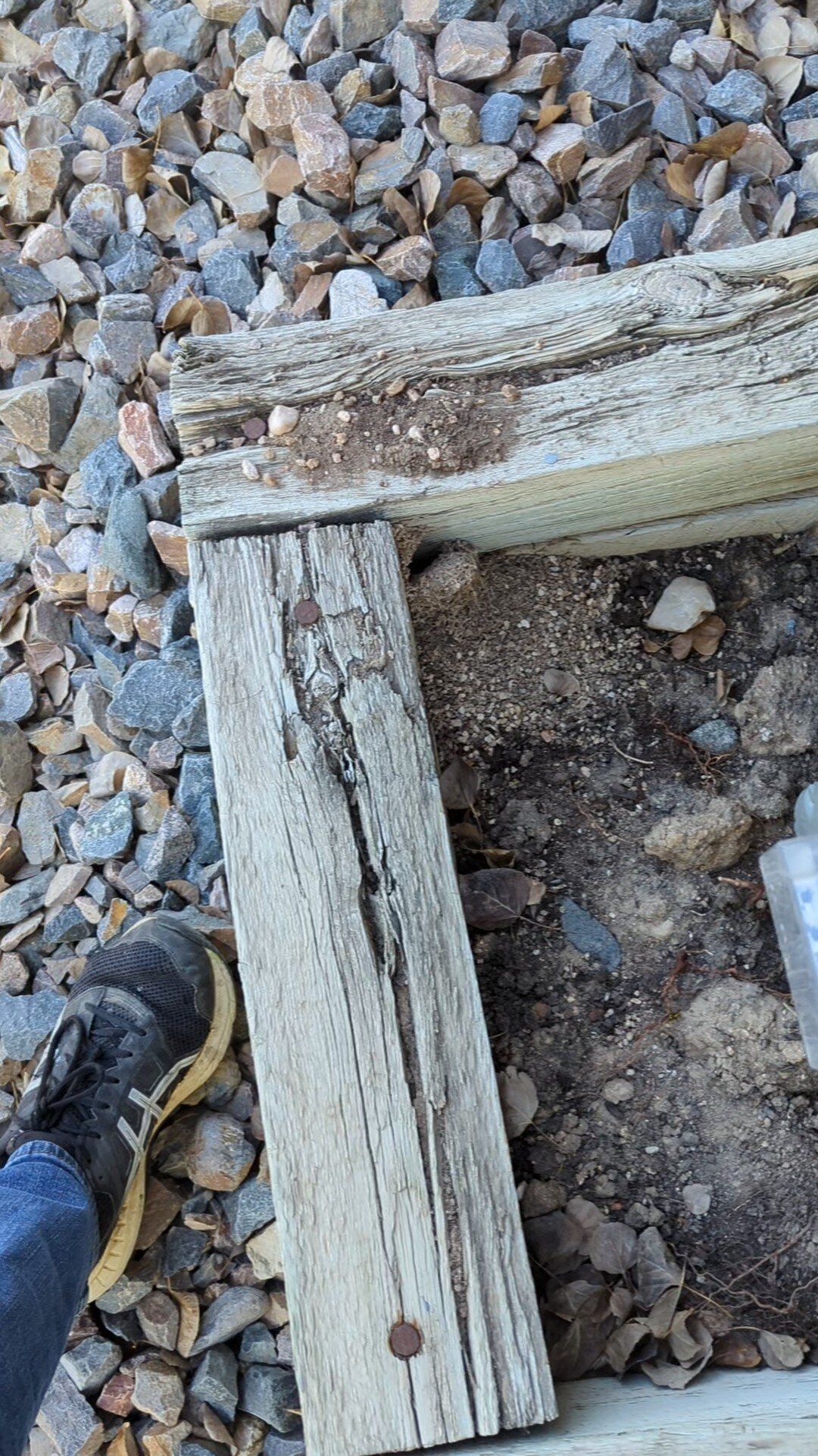 A piece of wood is sitting on top of a pile of rocks.