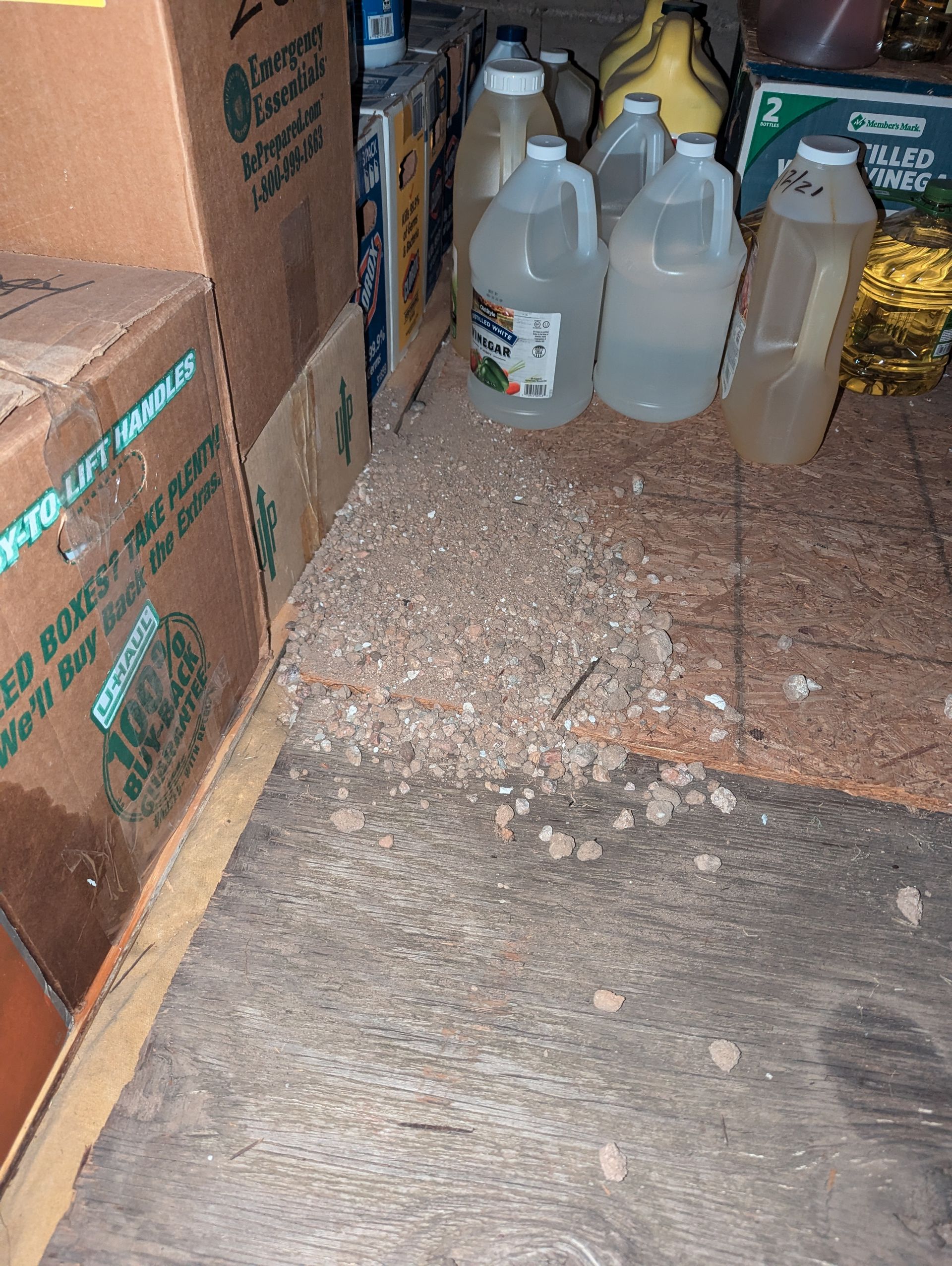 A bunch of bottles and boxes are sitting on the floor in a room.