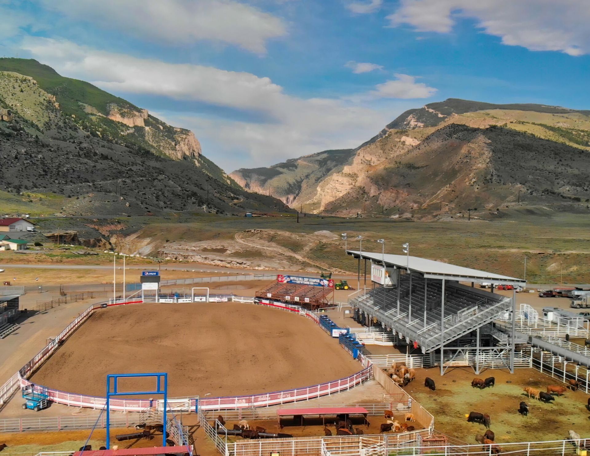 An aerial view of a rodeo arena with mountains in the background