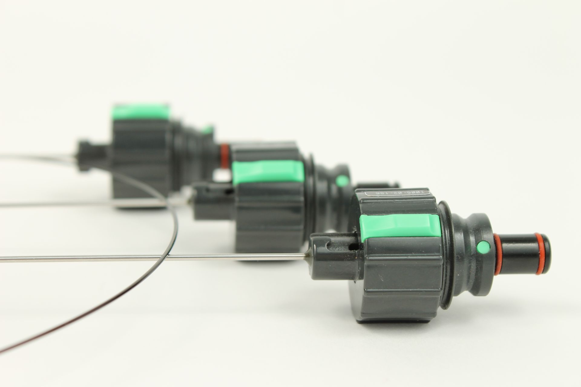 A row of black and green connectors on a white surface