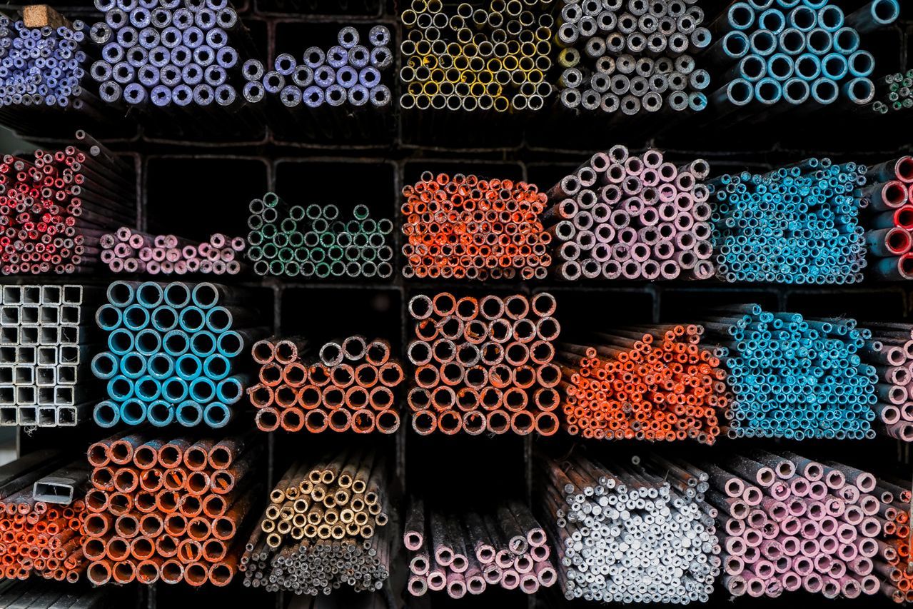 A bunch of different colored pipes are lined up on a shelf