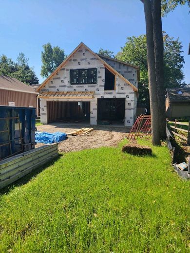 A house is being built in the middle of a lush green field.