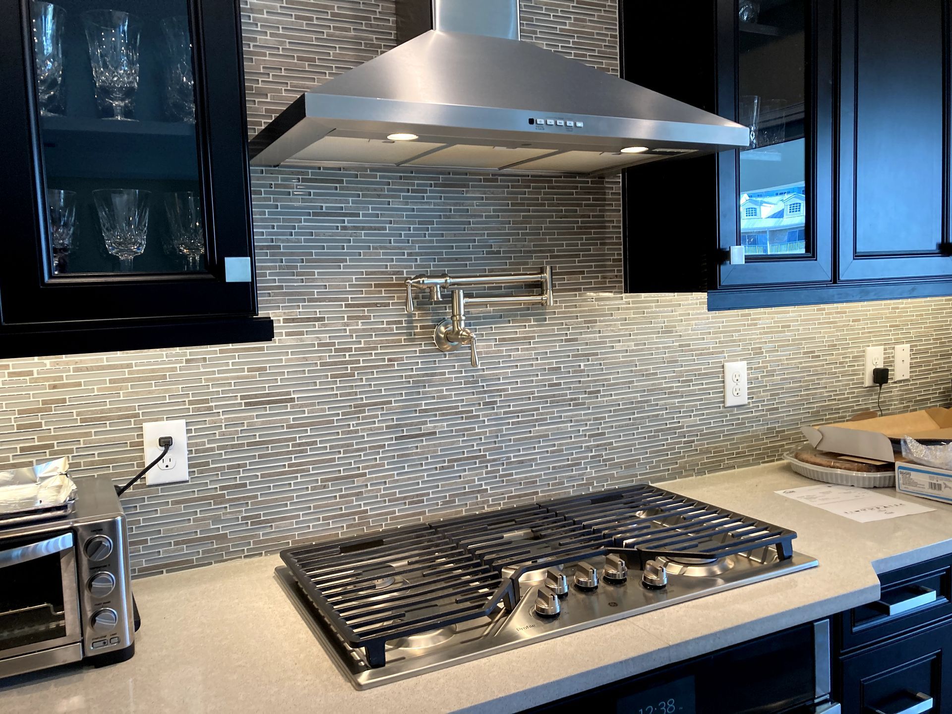 A kitchen with a stove top oven and a hood above it.
