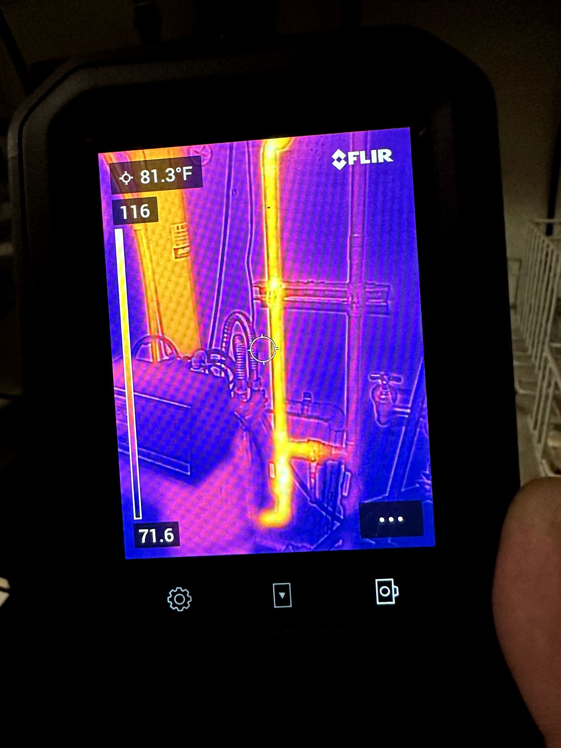 A person is holding a thermal camera in their hand.