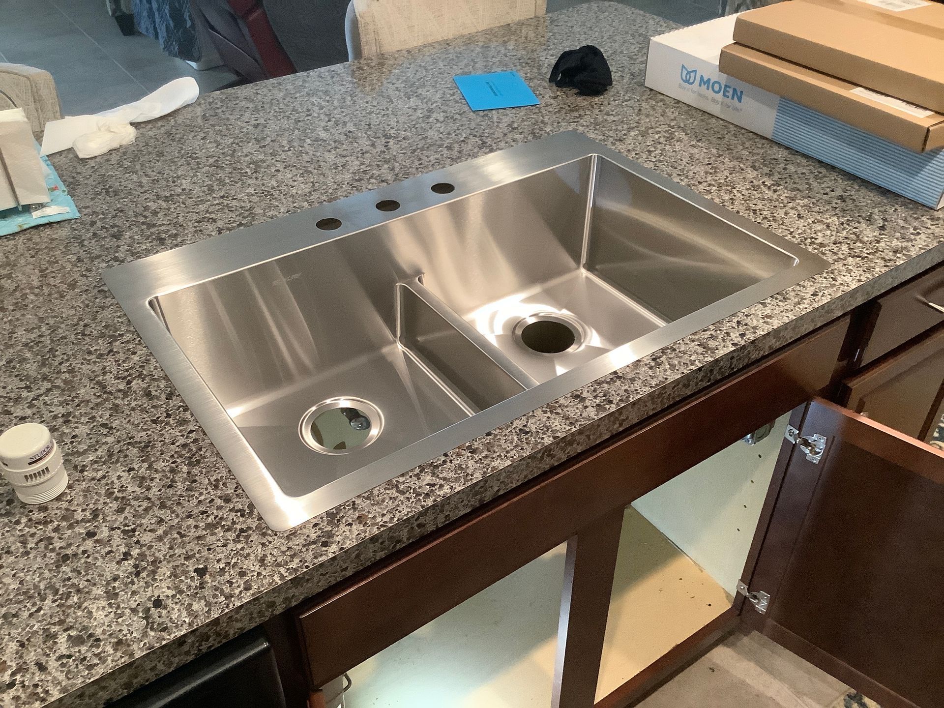 A stainless steel sink is sitting on top of a granite counter top.
