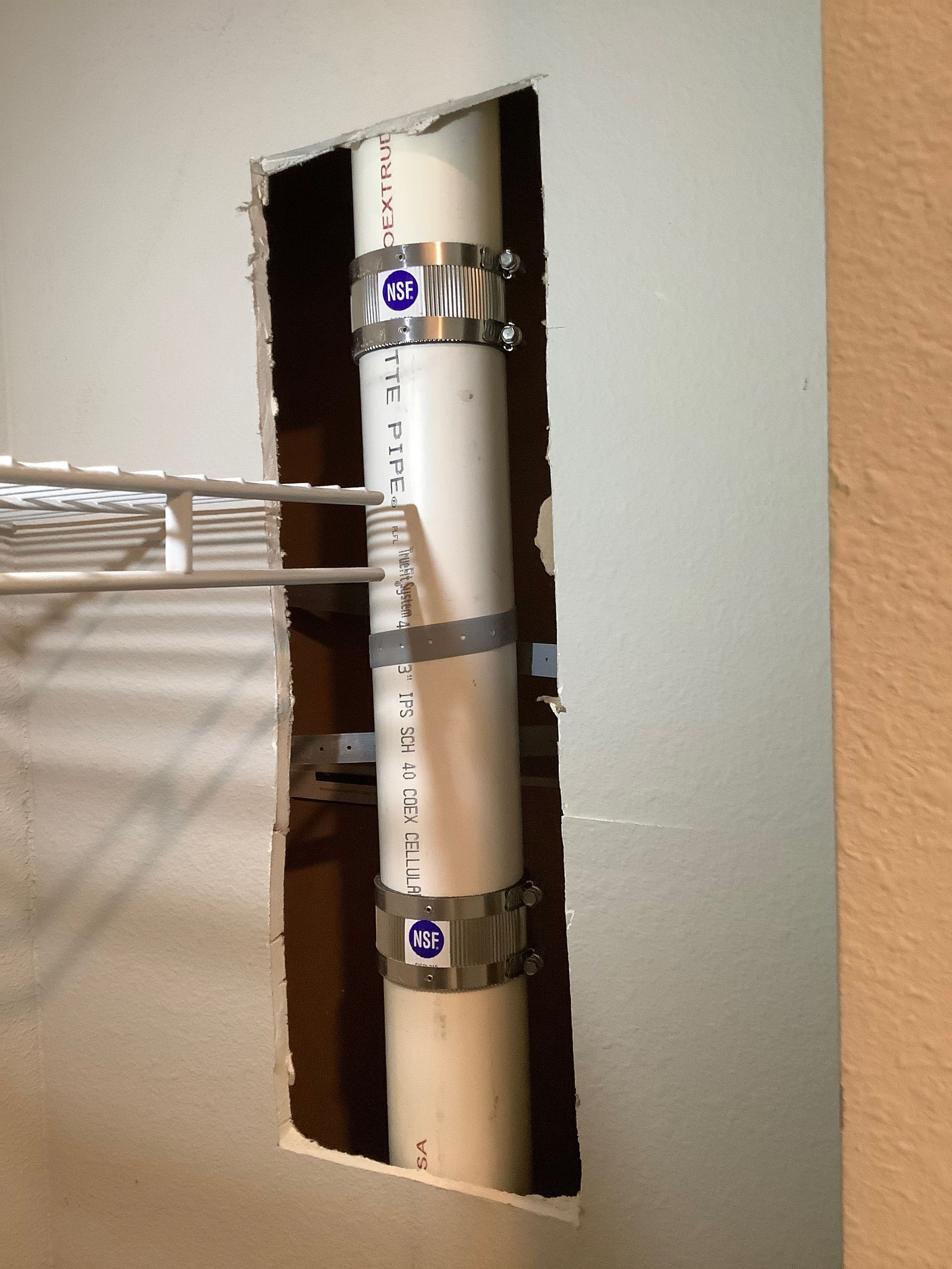 A hole in a wall with a pipe coming out of it