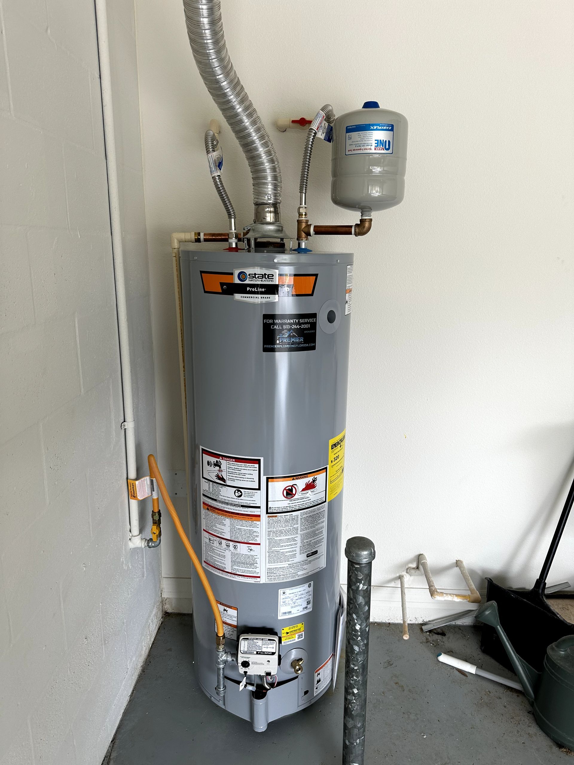A water heater is sitting in a room next to a wall.