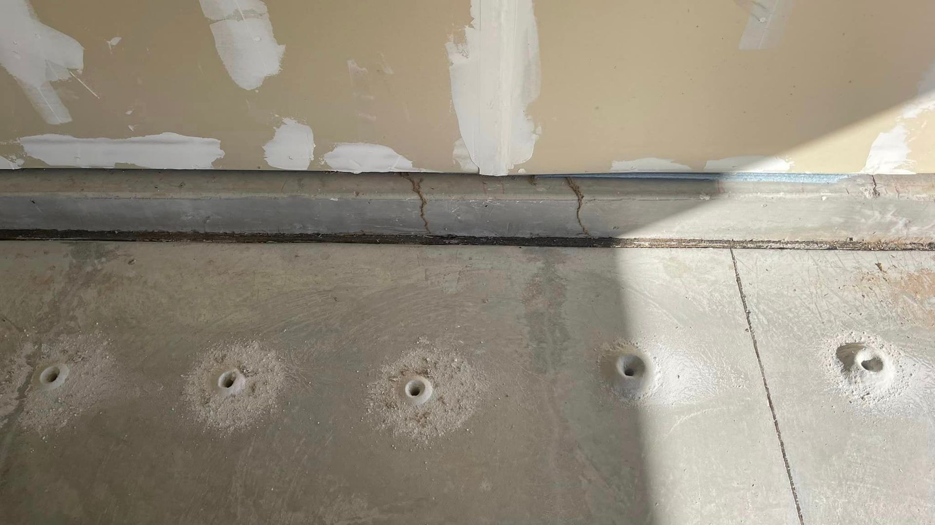 A close up of a concrete floor with holes in it.