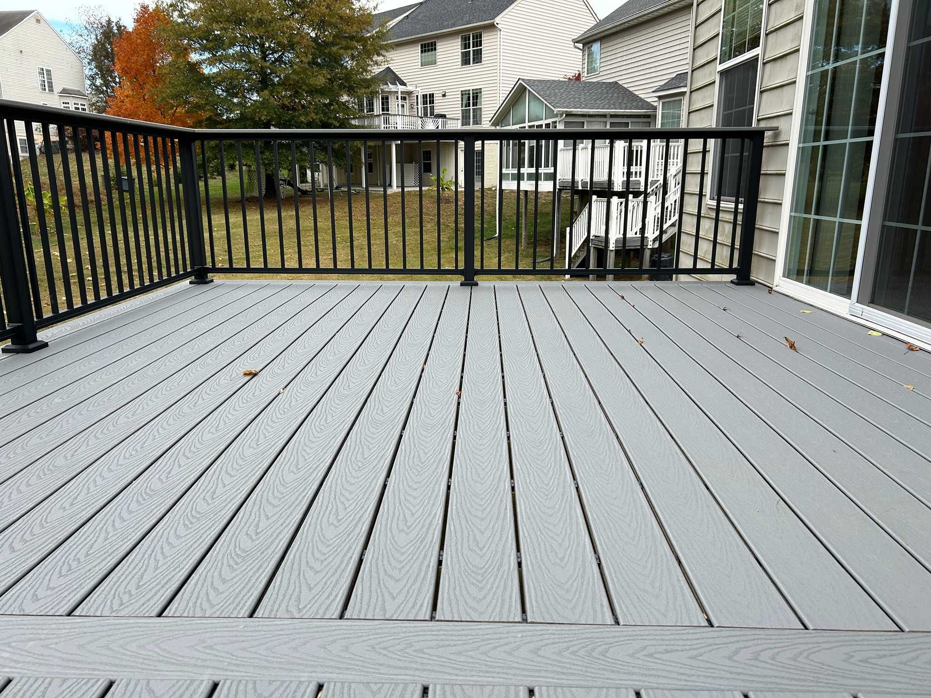 Gray composite deck with black railing overlooking a yard.