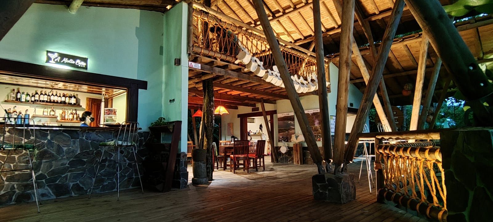 Rustic lodge interior with wooden beams, warm lighting, and a bar area