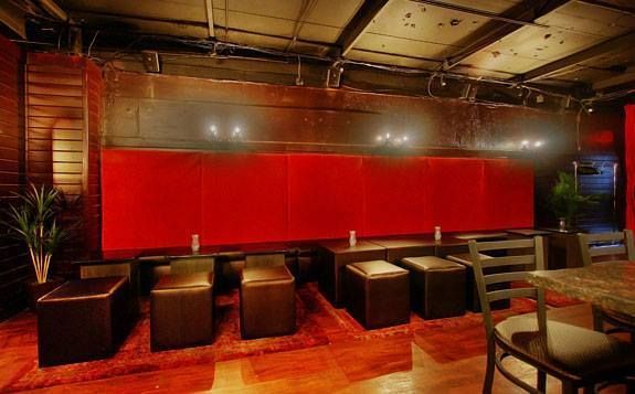 A restaurant with tables and chairs and a red wall