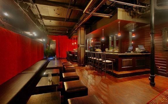 A restaurant with tables and stools and a bar