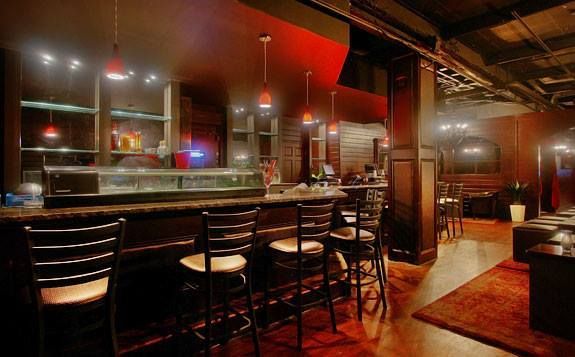 A bar with stools and a counter in a restaurant.