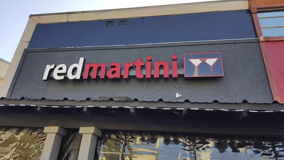 A red martini sign is on the side of a building