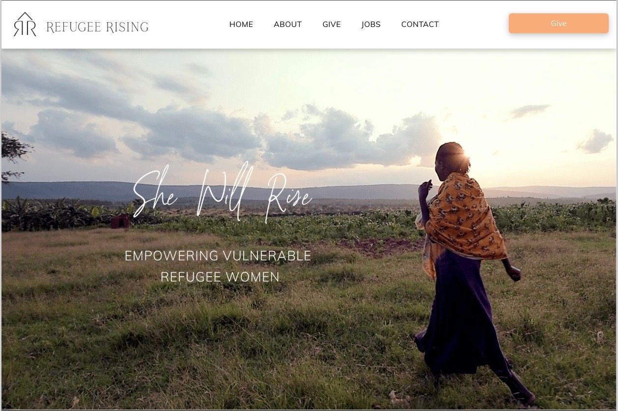 A woman is walking through a grassy field.
