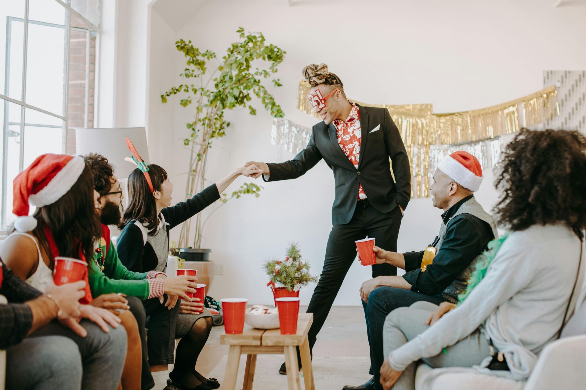 A group of people are sitting around a table at a christmas party.
