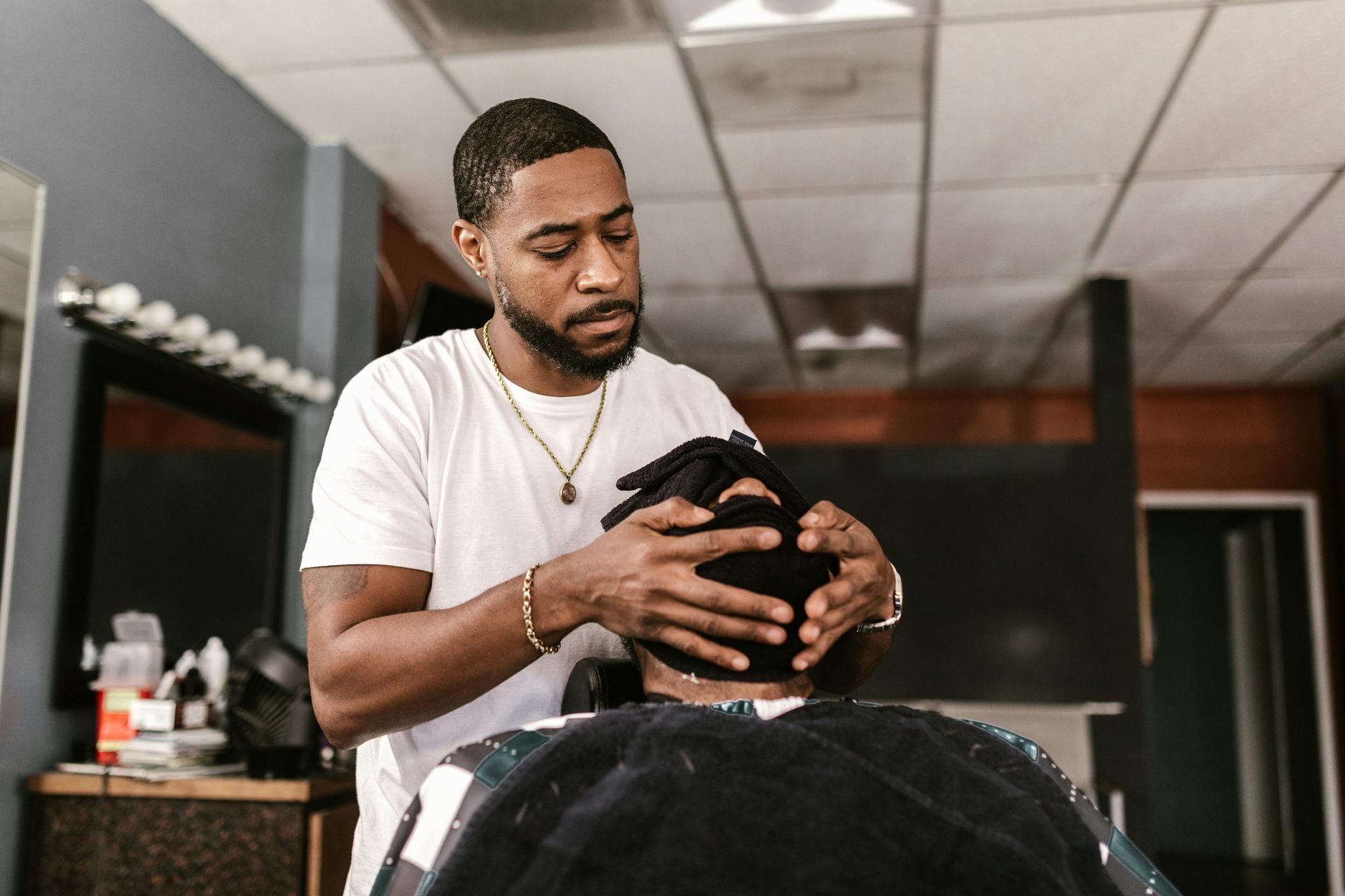 A man is cutting a man 's hair in a barber shop.