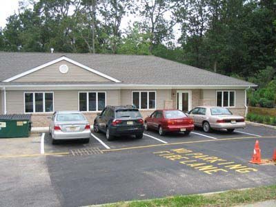 Several cars are parked in front of a building that says no parking