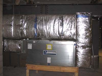 A metal box is sitting on top of a wooden table in a room.