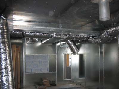 A room with a lot of metal pipes coming out of the ceiling.