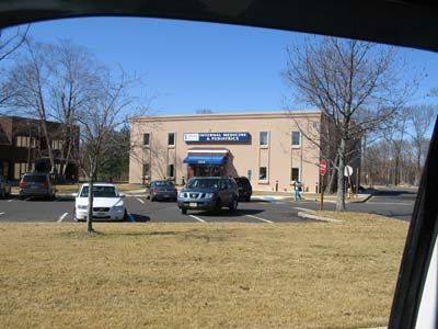 Cars are parked in a parking lot in front of a building that says ' a & a ' on it