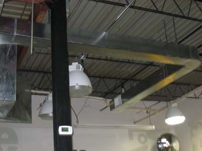 A large pipe is hanging from the ceiling of a building.