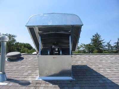 A metal box is sitting on top of a roof.