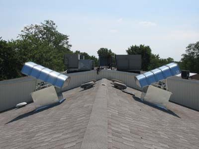 A roof with a lot of pipes on it and trees in the background