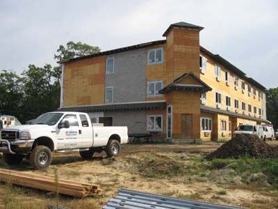 A white truck is parked in front of a building under construction