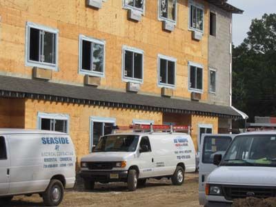Three seaside vans are parked in front of a building under construction