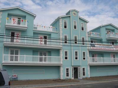 A large blue building with balconies and a clock on the top of it.