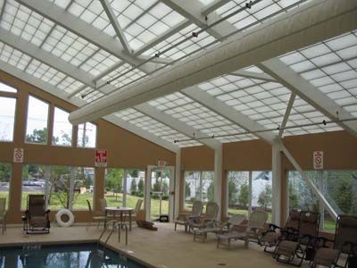 A large indoor swimming pool with a clear roof
