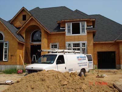 A white van is parked in front of a house under construction
