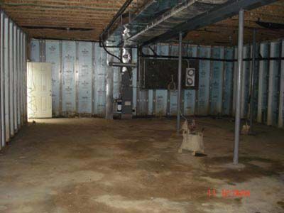 An empty basement with a heater and a door.