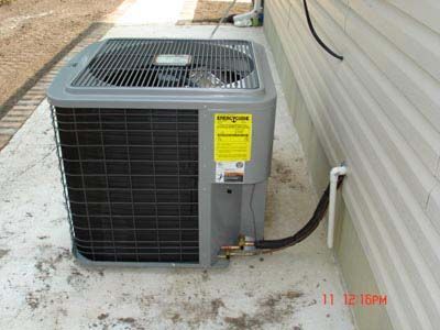 An air conditioner is sitting on the side of a building.