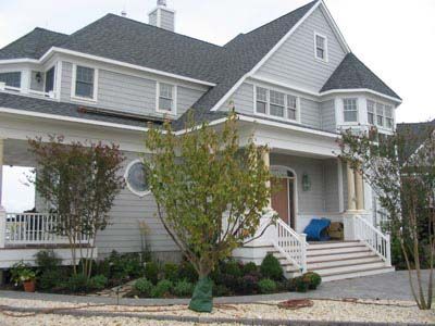 A large house with a gray roof and white trim