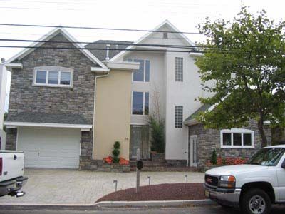 A white truck is parked in front of a large house