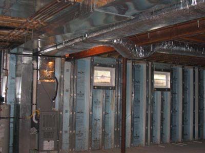 A basement with a lot of insulation and ductwork.