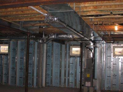 A basement with a lot of pipes hanging from the ceiling.